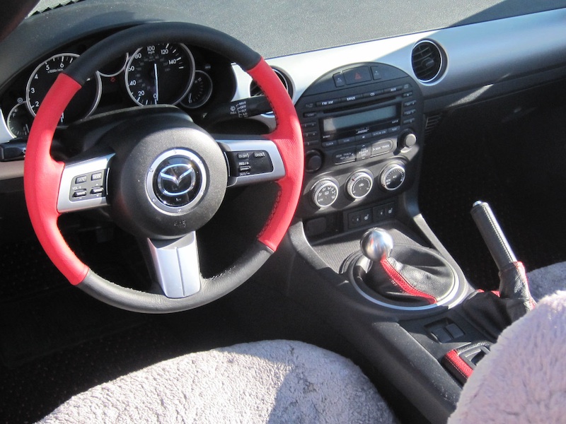 Mazda Miata steering wheel with increased girth and thumb-grips and a red racing stripe